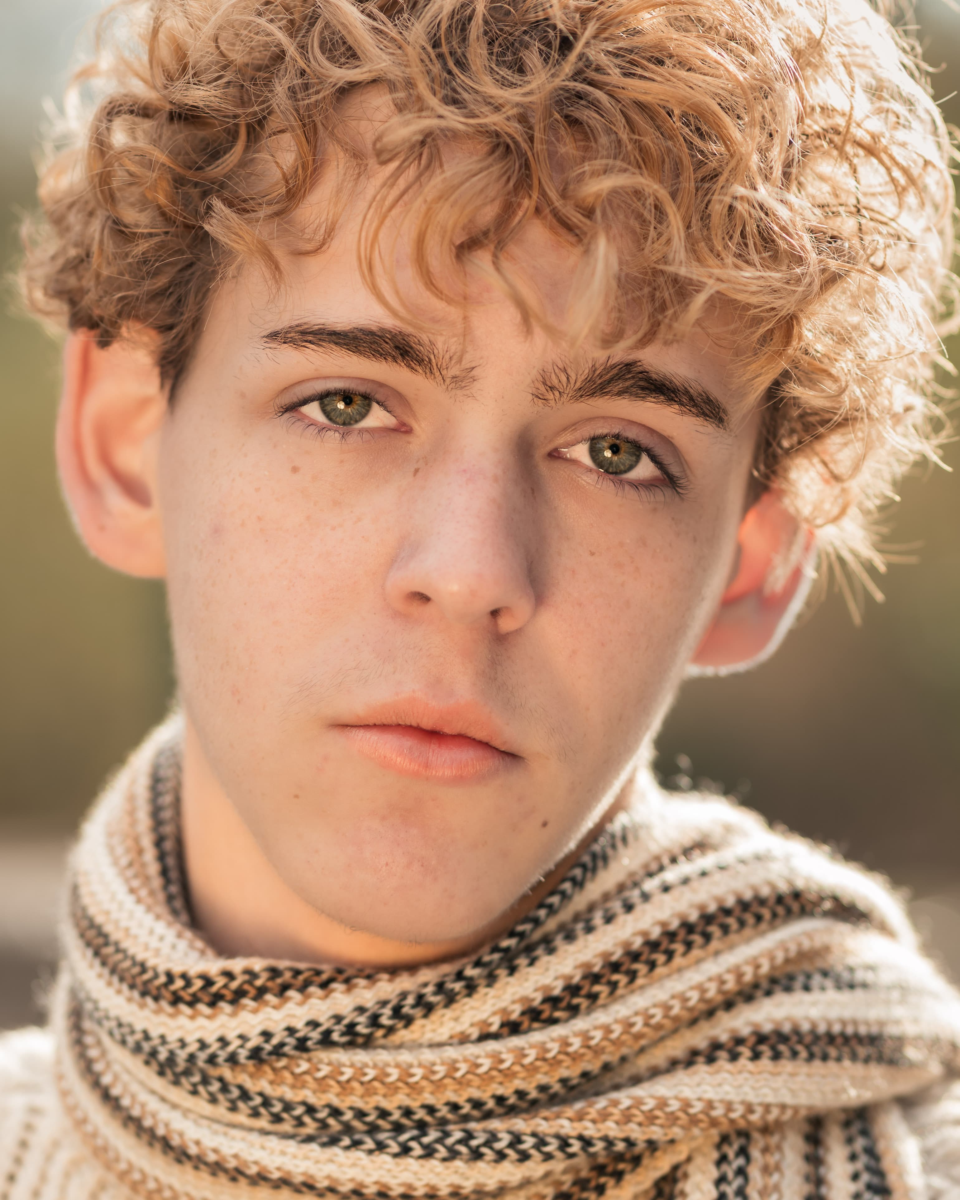 Nahes Portrait eines jungen Mannes mit Schal im warmen Abendlicht